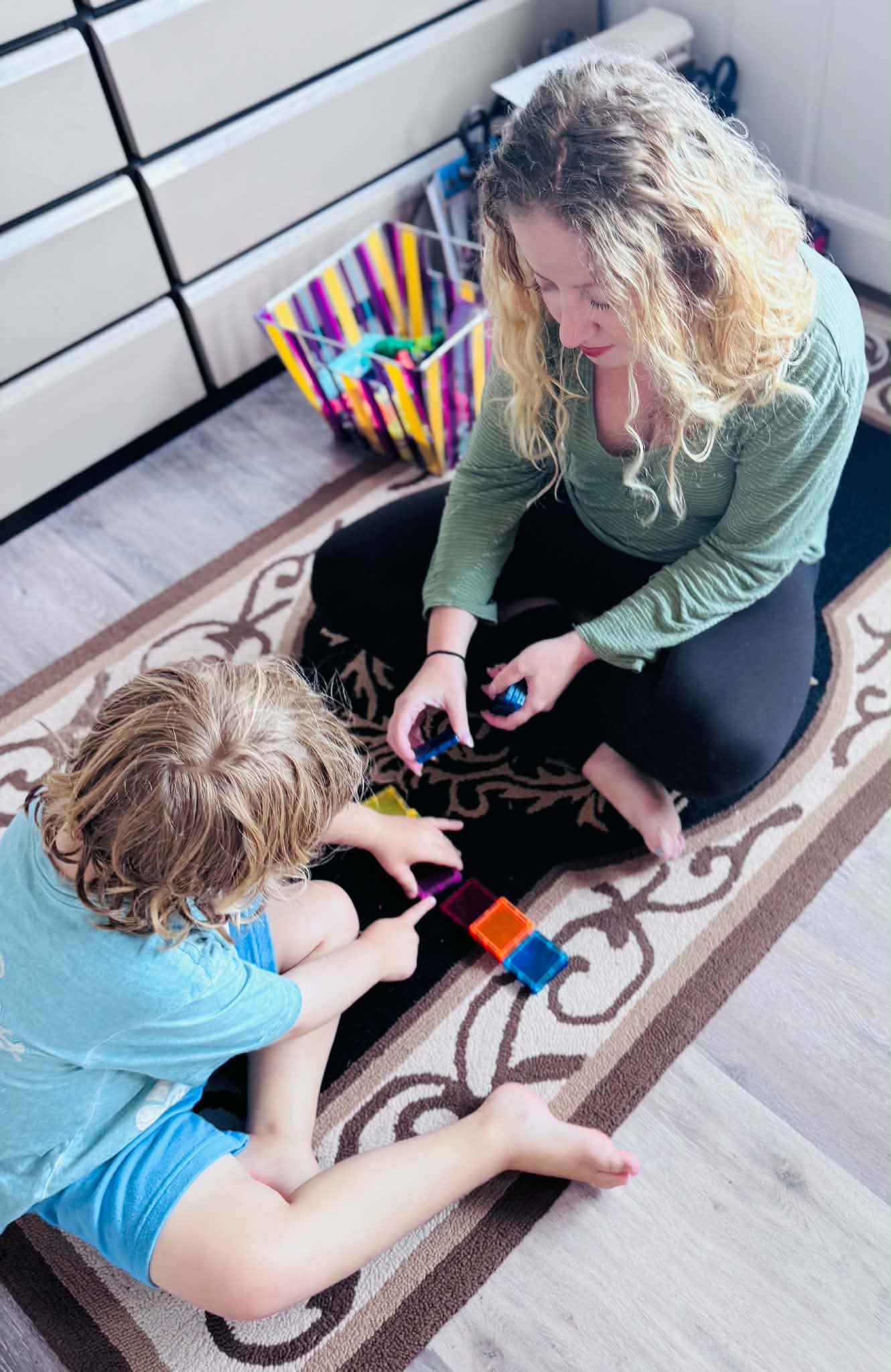 An adult and child playing together during a pediatric occupational therapy session in a home environment